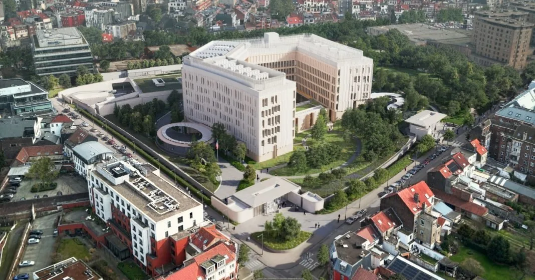 Vue aérienne d'un bâtiment moderne entouré de verdure, dans un quartier urbain résidentiel.